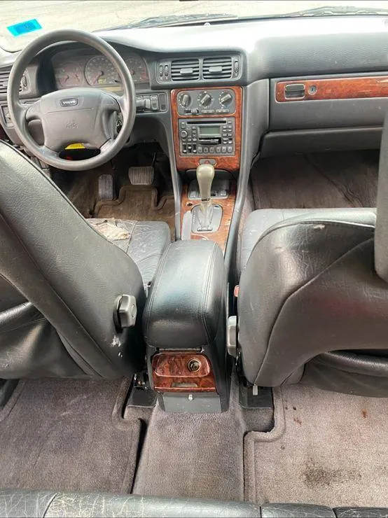 Same Volvo interior after a full detail — debris removed, carpets vacuumed, console and dash cleaned