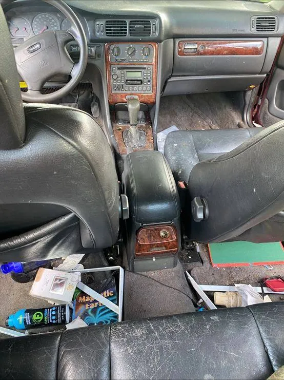 Volvo interior before detailing — trash and debris throughout the cabin